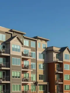 Modern affordable housing complex with Canadian flag, representing federal investment.