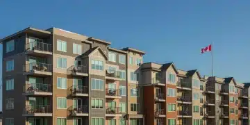 Modern affordable housing complex with Canadian flag, representing federal investment.